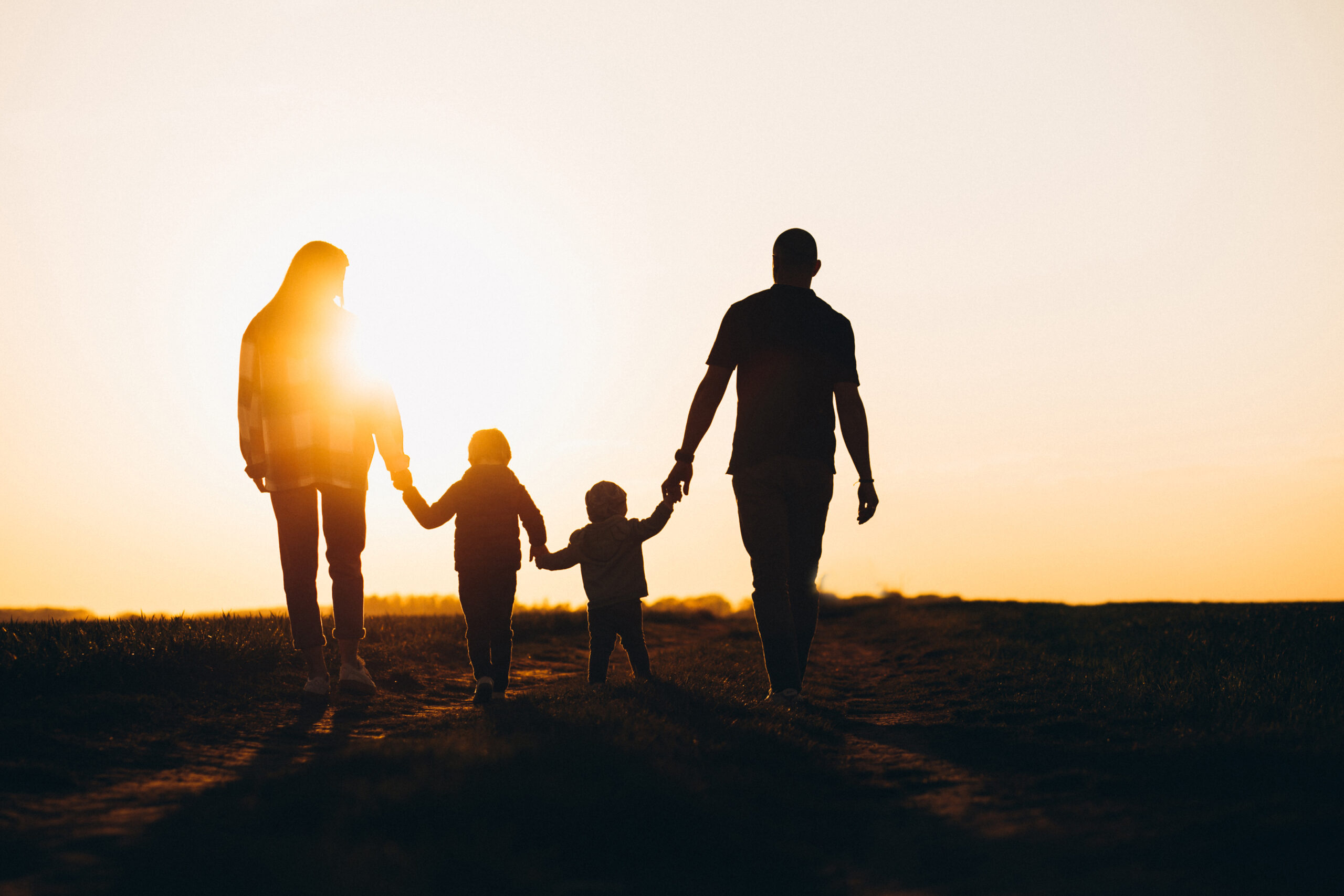 Happy family silhouette on the sunset Family walking together into the sunset